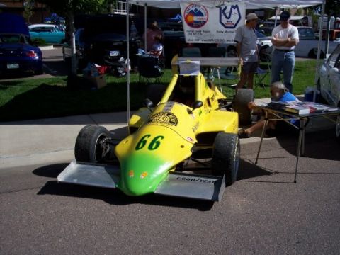 1972 Ford Ranchero - A yellow and green open-wheel race car numbered 66 is displayed at an outdoor car show.