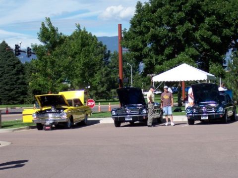 1972 Ford Ranchero - A yellow 1960 Ford Ranchero is displayed with its hood open at a car show, alongside other vehicles.