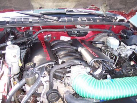 1972 Ford Ranchero - Close-up of an engine bay 'CORVETTE' branded valve covers and a large green intake hose.