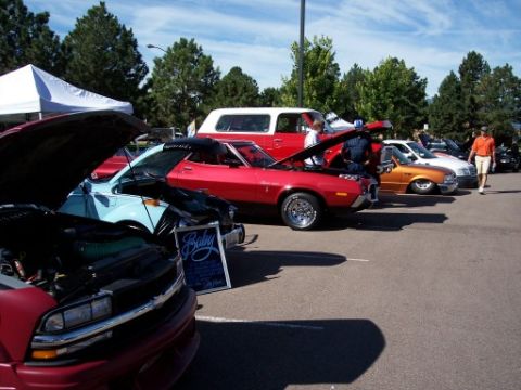 1972 Ford Ranchero - Several cars are displayed with their hoods open at an outdoor car show.