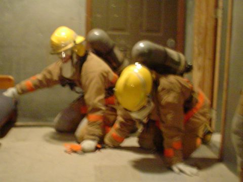 1981 Ford Bronco - Firefighters train in protective gear, equipped with oxygen tanks, simulating an emergency response scenario.