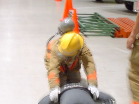 1981 Ford Bronco - Firefighter training exercise with a dummy, safety cones and equipment.