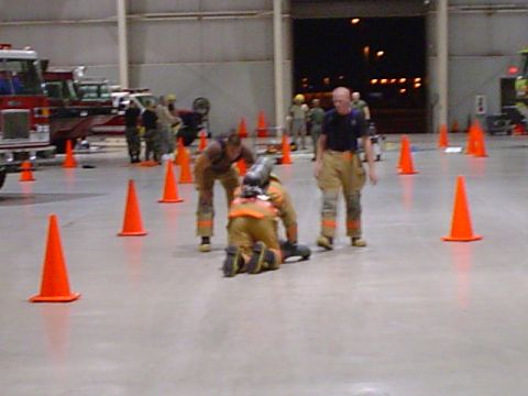 1981 Ford Bronco - Firefighters conduct training exercises indoors, navigating around traffic cones with fire apparatus nearby.