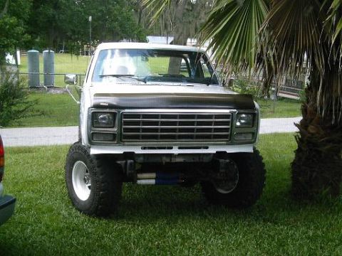 1986 Ford Bronco - Front view of a lifted pickup truck with a custom grille and off-road tires.