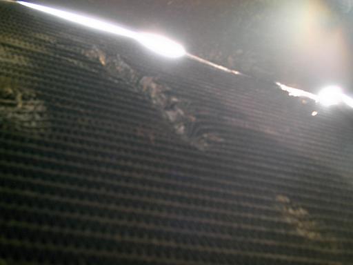 Damaged radiator fins with debris stuck between them