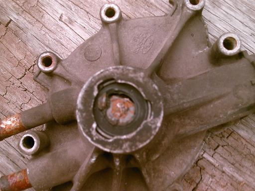 Close-up of a rusty metal part with a Ford logo embossed on it
