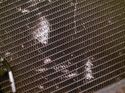 1986 Ford Bronco - The radiator fins are bent and damaged, indicating a potential issue with cooling efficiency.