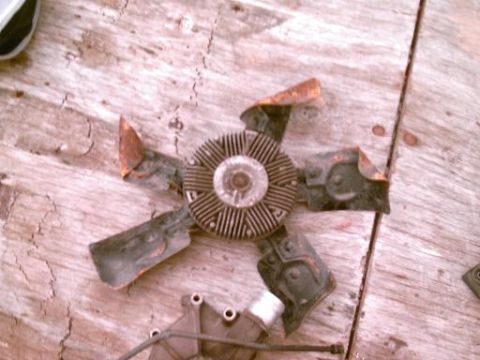 1986 Ford Bronco - A rusted engine cooling fan part is shown on a wooden surface.