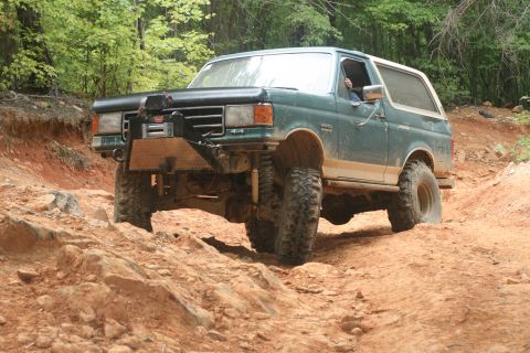 1990 Ford Bronco - This 1990 Ford Bronco navigates a challenging off-road course with large tires and a lifted suspension.