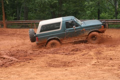 1990 Ford Bronco - Ford Bronco navigating a muddy off-road course.