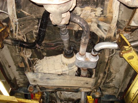 1994 Ford Bronco - The undercarriage of a vehicle is shown, focusing on the drivetrain and exhaust components.