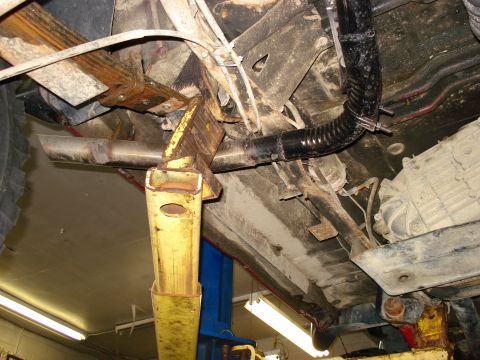 1994 Ford Bronco - Undercarriage view shows the exhaust system, leaf springs, and a jack supporting the vehicle.
