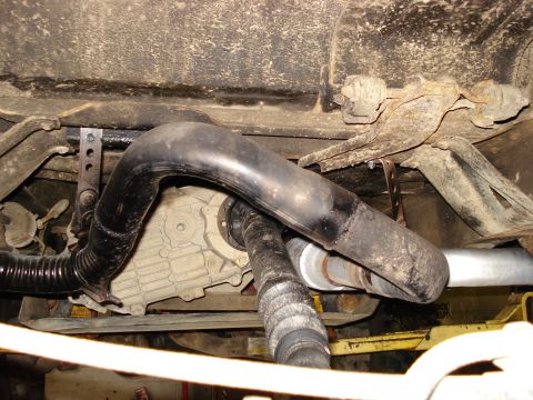 1994 Ford Bronco - Underside view shows exhaust piping and the transfer case of a vehicle.