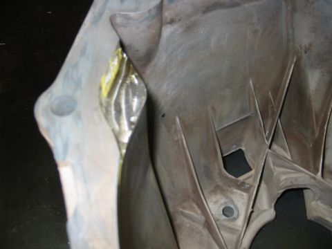 1993 Ford Taurus - A gray plastic automotive part with yellow tape is shown in a close-up view.