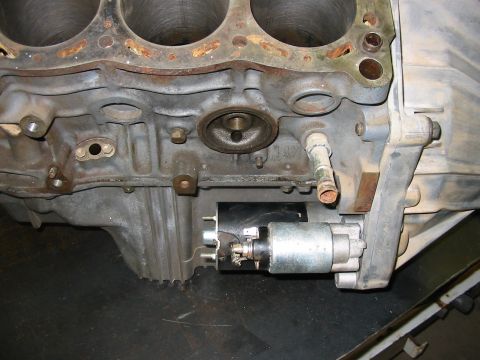 1993 Ford Taurus - This image shows a close-up view of an engine block and its attached starter motor.