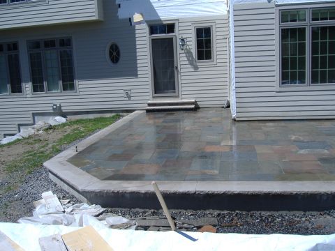 1998 Ford Taurus - A new stone patio is being installed in front of a house with siding and windows.