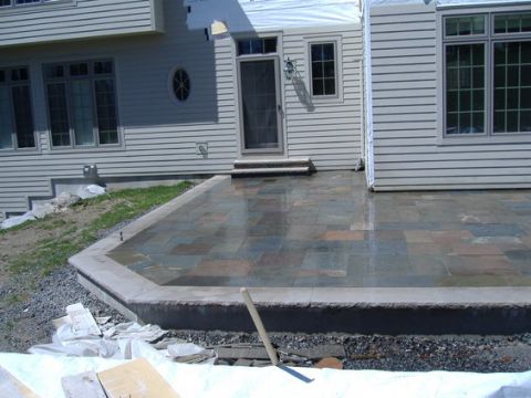 1998 Ford Taurus - A new stone patio is installed next to a house under construction, with building materials visible in the foreground.