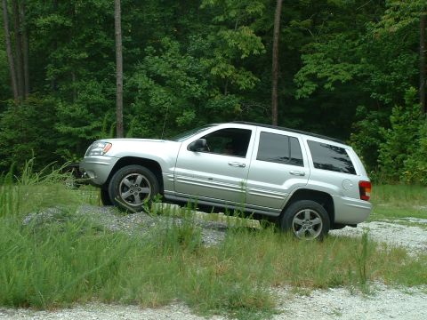 1995 Ford Bronco - A silver Jeep Grand Cherokee is shown on an incline in a wooded area.