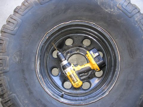 1994 Ford Bronco - A drill and bit are placed on a tire rim, suggesting a repair or modification is underway.