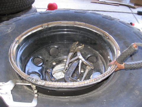 1994 Ford Bronco - Tools are placed on a tire rim that has rebar welded around its circumference.