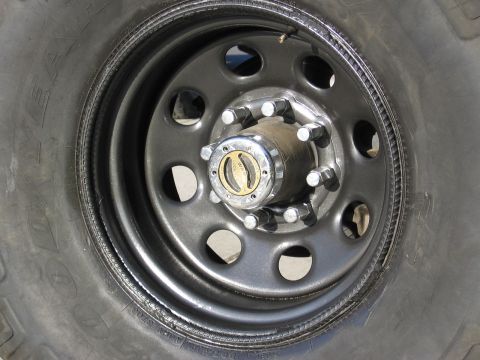 1994 Ford Bronco - A detailed view of a vehicle's wheel, focusing on the hub and tire tread. The hub features a locking mechanism.
