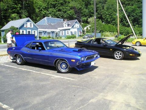 1984 Pontiac Fiero - Two classic American muscle cars, a blue Dodge Challenger and a black Pontiac Firebird, are parked outside.