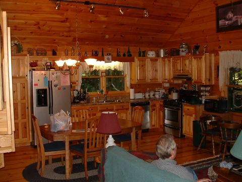 1995 Ford Bronco - A view of a rustic kitchen and dining area inside a log cabin, wooden furniture and appliances.