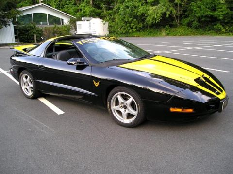 1984 Pontiac Fiero - This black 1994 Pontiac Trans Am features bold yellow racing stripes and a matching yellow roof.