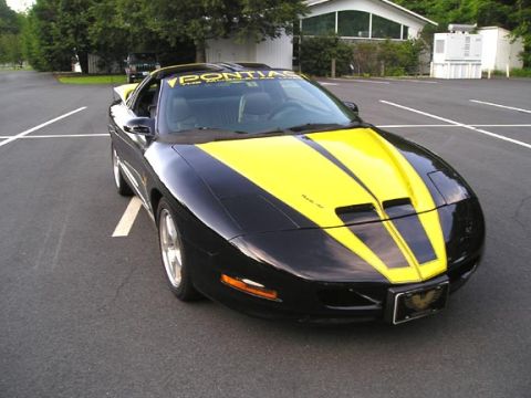 1984 Pontiac Fiero - This 1994 Pontiac Trans Am has black paint with yellow racing stripes and a 'Pontiac' banner on the windshield.