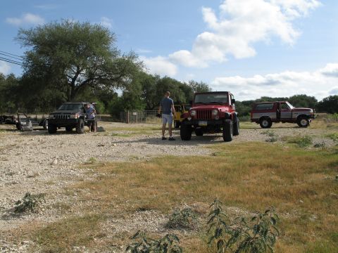 1995 Ford Bronco - A red and white 1995 Ford Bronco is parked in a field next to a red Jeep Wrangler.