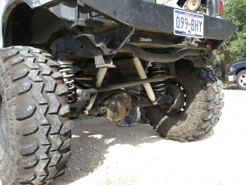 1995 Ford Bronco - The rear suspension and axle of a modified off-road vehicle are visible, along with a Texas license plate.