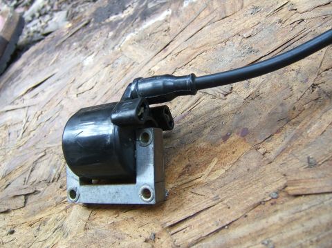 1996 Ford Probe - Close-up of an automotive ignition coil resting on a wooden surface.