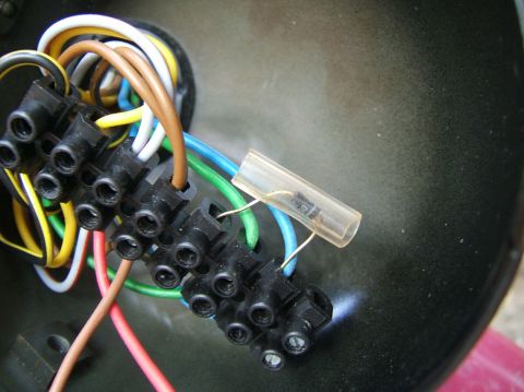 1996 Ford Probe - A close-up view of a vehicle's electrical wiring harness, showing a terminal block and a diode.
