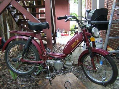 1996 Ford Probe - This moped has an 'EAGLE' logo on its maroon gas tank and is parked outside.