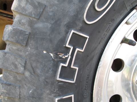 1995 Ford Bronco - A close-up view of a tire shows damage to the tread and some text indicating its origin.