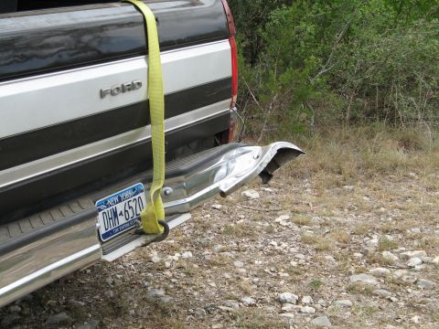 1995 Ford Bronco - Rear view of a Ford pickup truck, showing a damaged bumper and a yellow strap.
