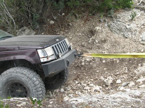 1995 Ford Bronco - This Jeep Grand Cherokee appears to be stuck and is being pulled by a tow strap.