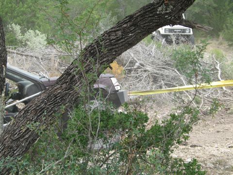 1995 Ford Bronco - Two off-road vehicles are in a wooded area, one appears to be involved in an incident with a fallen tree.