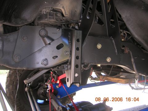 1996 Ford Bronco - Custom suspension components are bolted to the vehicle's frame, with red straps securing parts underneath.
