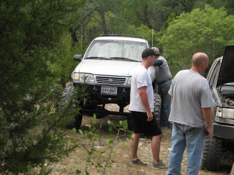1995 Ford Bronco - Off-road vehicles and people gathered in a wooded area.