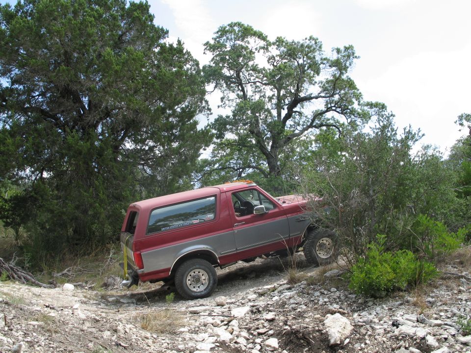 Red and silver 1995 Ford Bronco on a rocky trail