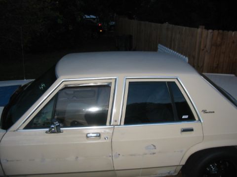 1985 Ford LTD Crown Victoria - This 1985 Ford Crown Victoria LTD sedan is seen from the side, showing its tan exterior.