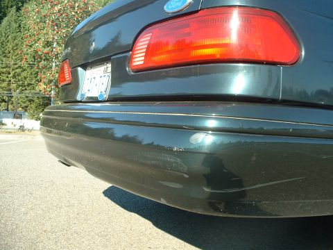 1995 Ford Taurus - Rear view of a dark green 1995 Ford Taurus, highlighting its bumper and taillight details.