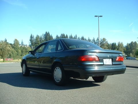 1995 Ford Taurus - Rear view of a dark green 1995 Ford Taurus sedan parked in a lot.