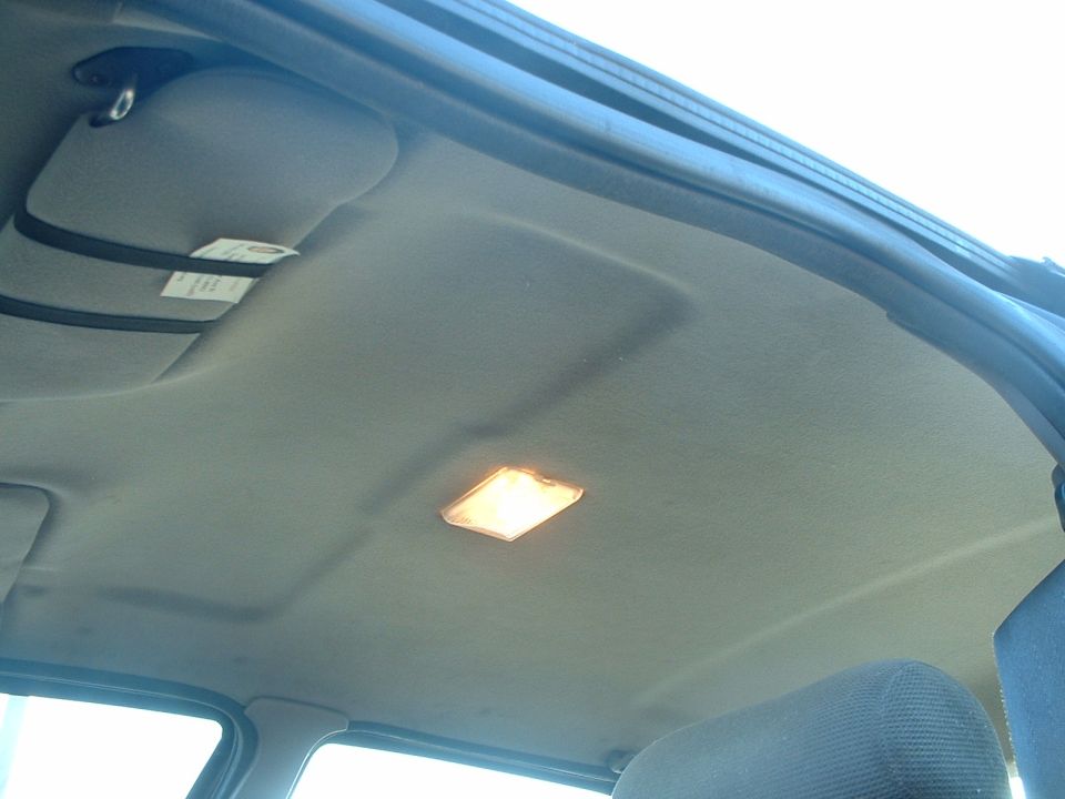 Car's interior ceiling with a sun visor and a light fixture