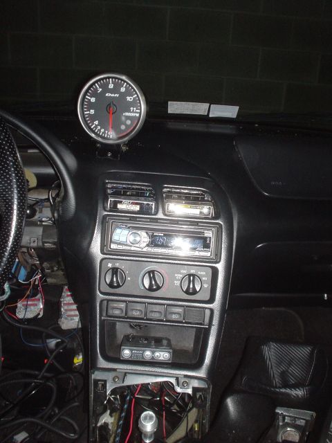 1995 Ford Probe - The interior of a 1995 Ford Probe shows a tachometer, stereo, and visible wiring, indicating modifications.