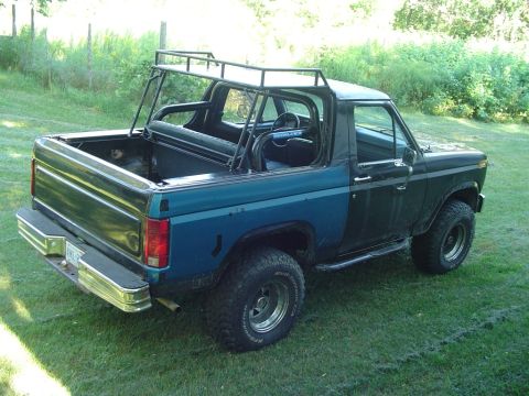1986 Ford Bronco - This Ford Bronco has a custom roll cage and roof rack installed, with a two-tone paint job.