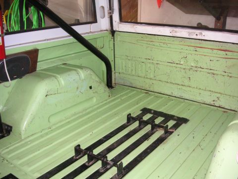 1999 Jeep Grand Cherokee - The interior cargo area of a vehicle is shown with green paint and black tie-down rails.