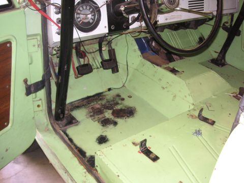1999 Jeep Grand Cherokee - Interior of a vintage vehicle, a dashboard gauge and floor pedals, with visible wear and tear.