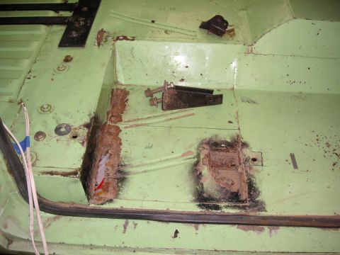 1999 Jeep Grand Cherokee - The interior floor pan shows significant rust damage and has some loose brackets and wiring.